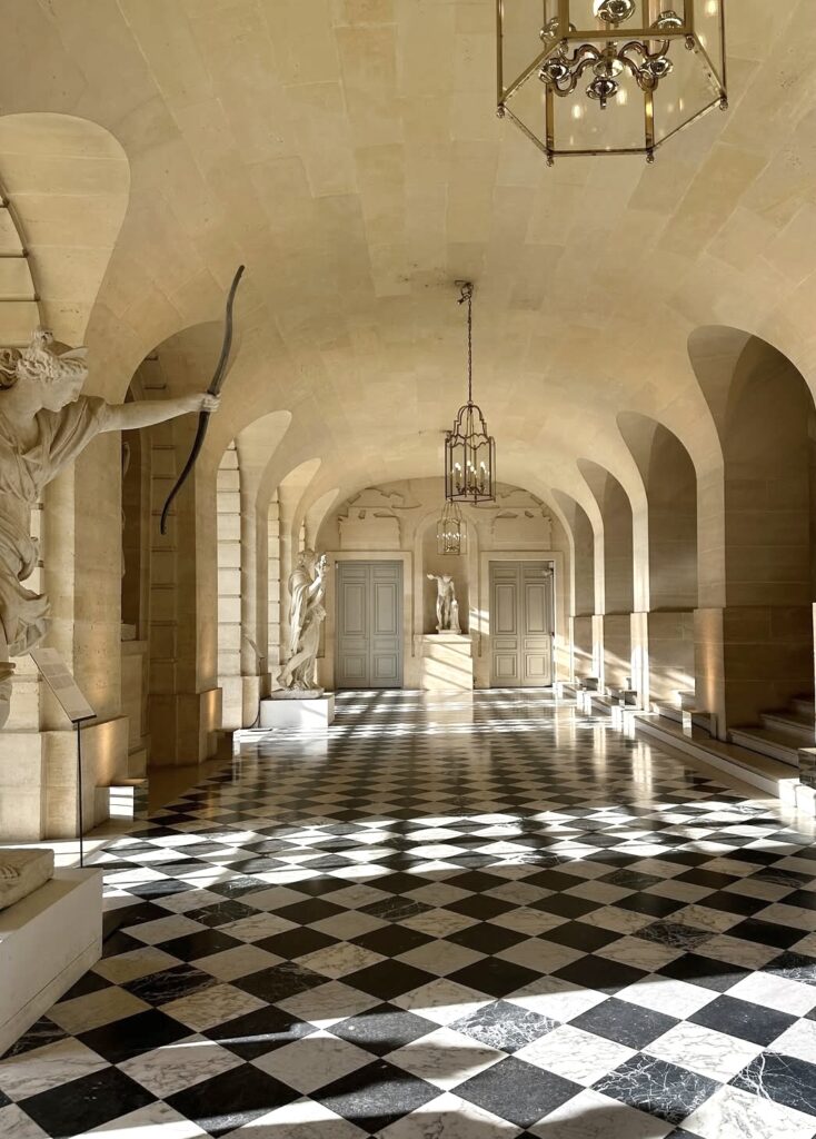 Parisian museum hallway with golden light, arched ceiling, and soft neutral palette